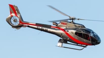 Airbus H125 helicopter in red and black livery - Premium helicopter transfer and scenic tour services in Costa Rica