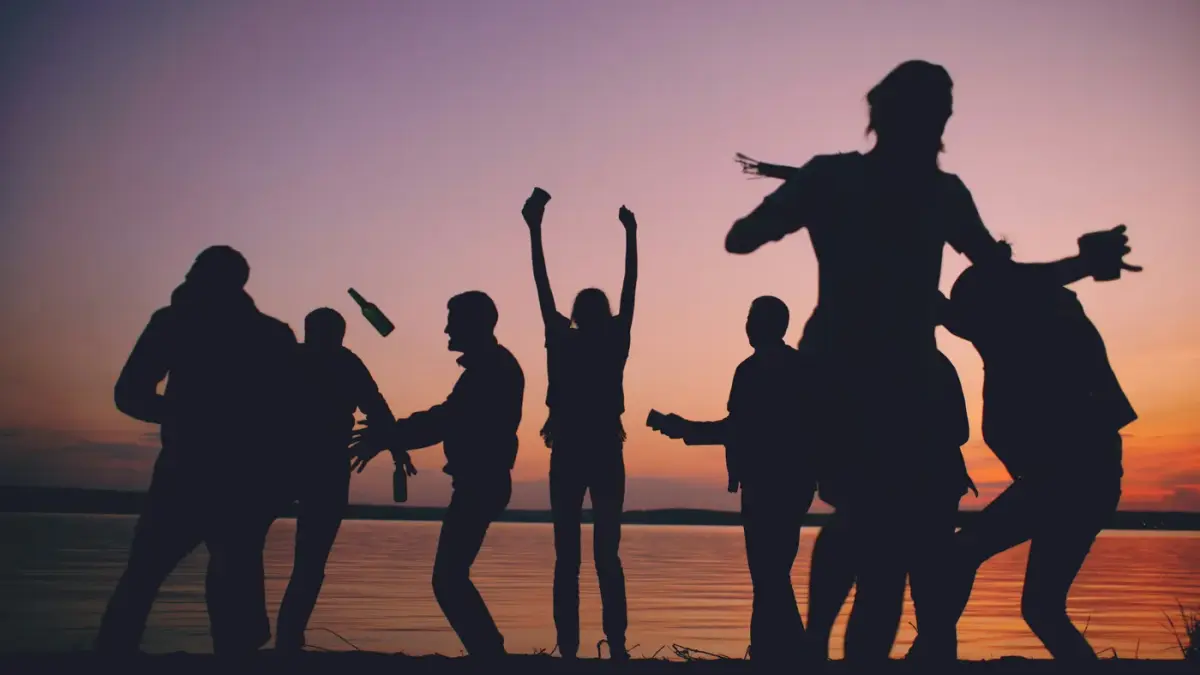 Group of friends celebrating and enjoying nightlife beach party in Jaco