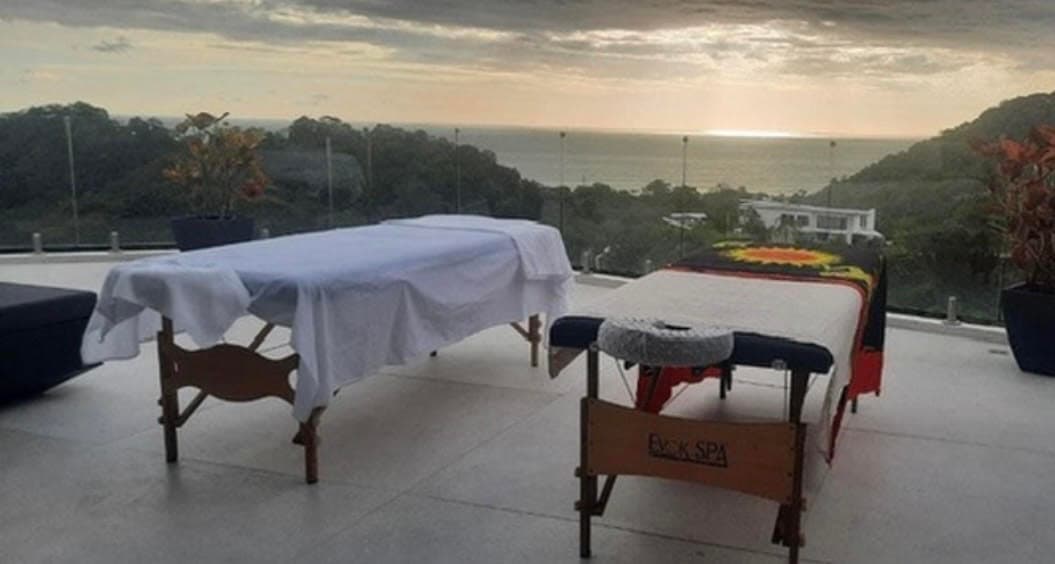 Professional massage tables on outdoor terrace with ocean views at sunset in Costa Rica