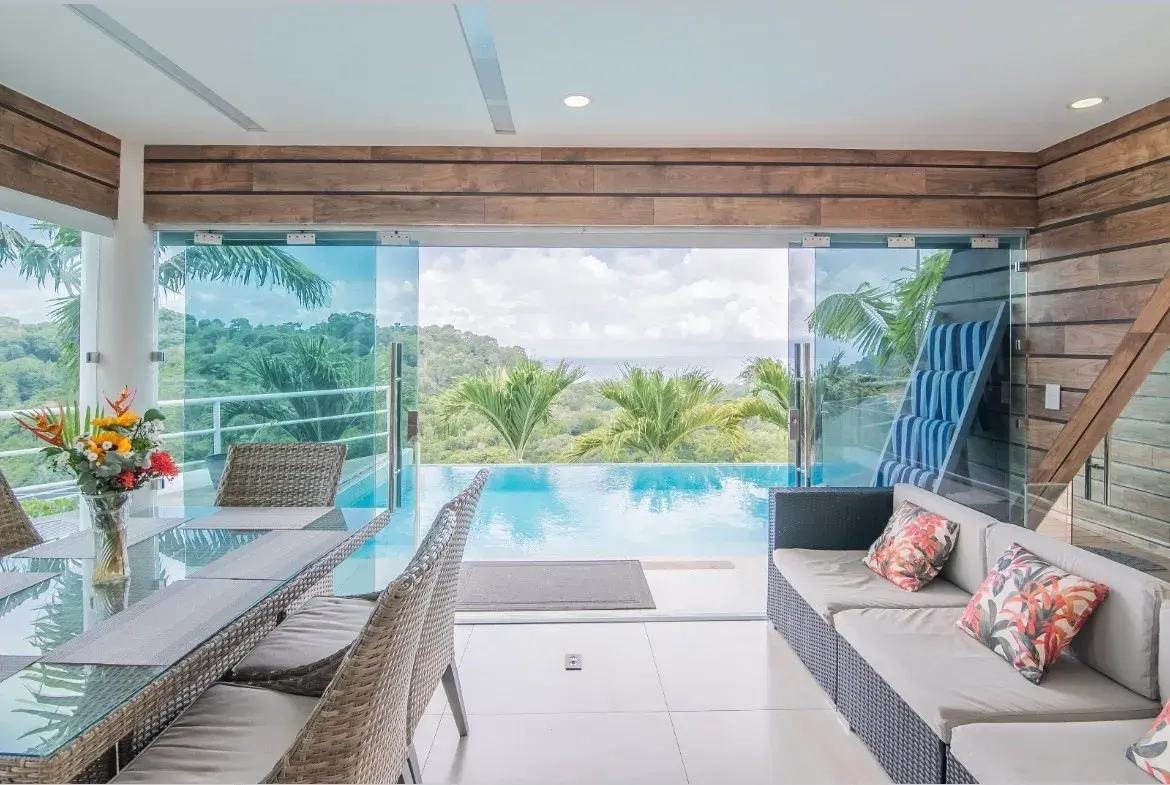 Romantic tropical outdoor dining setup overlooking an infinity pool and jungle